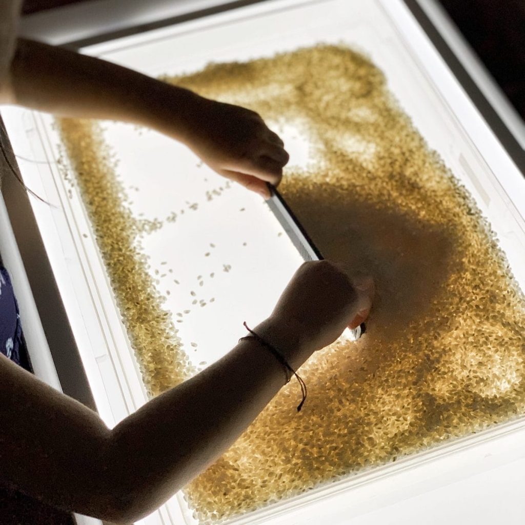 light table play with rice and comb
