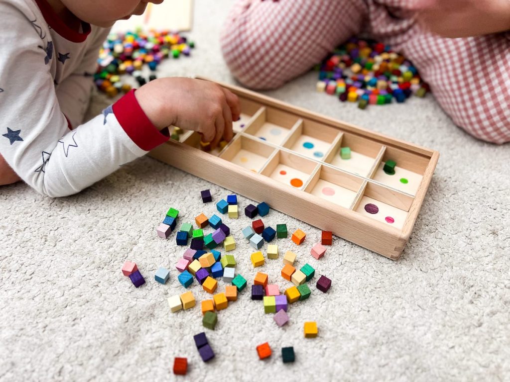 siblings color sorting the mis&match cubes into the sorting box